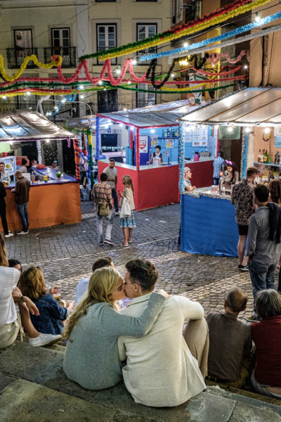 Photographie d'un couple s'embrassant dans les rues de l'Alfama lors des Festas de Lisboa